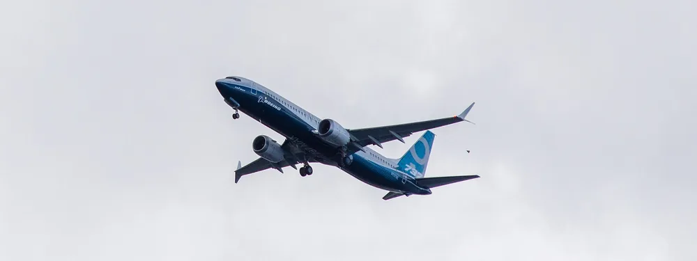 Boeing 737-9 MAX test aircraft N7379E in Boeing house livery climbing under an overcast sky