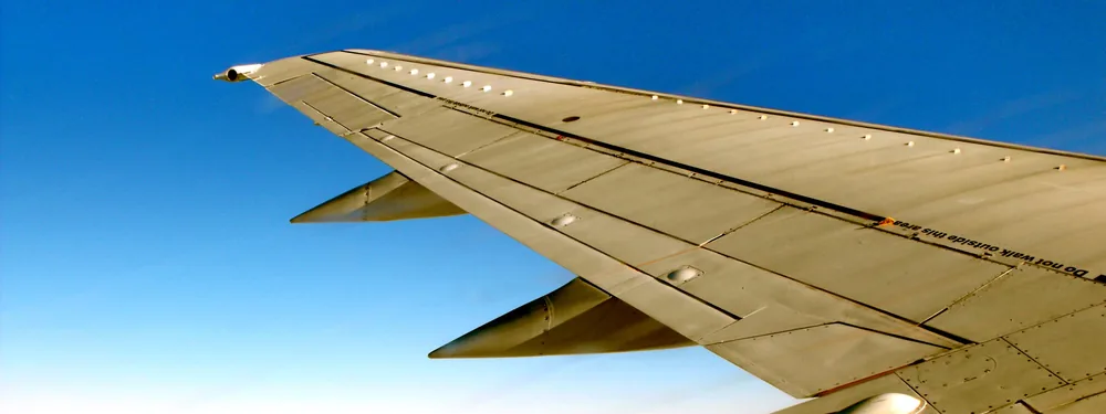 Wing and winglet of a Boeing 737 above a layer of cloud, seen from a cabin window